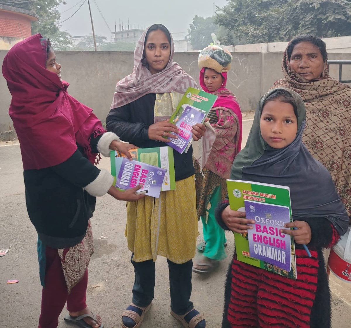 Volunteers handing books to a family