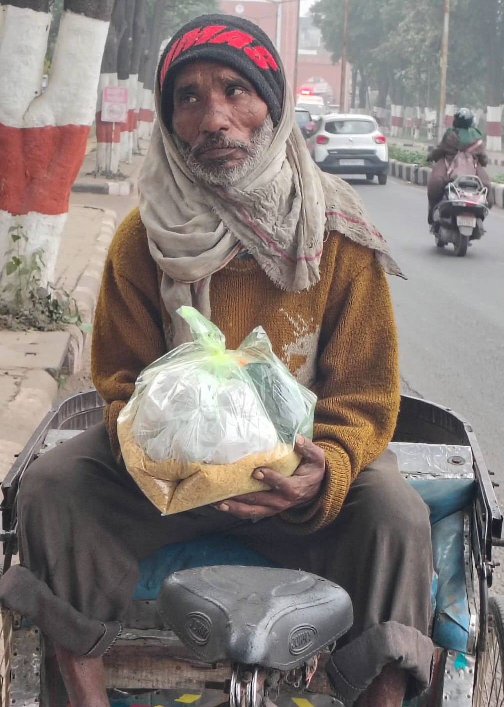 Elderly man on a rickshaw with relief supplies
